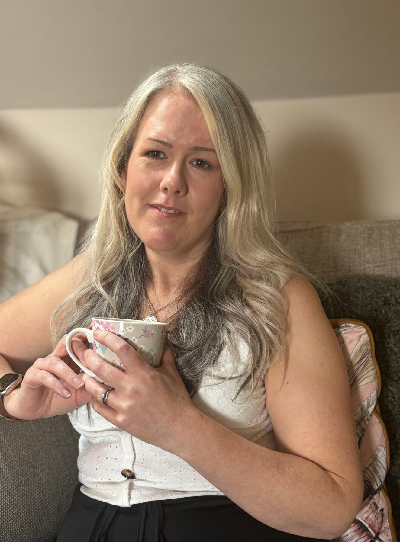 Laura from Laura Heslop Therapy holding a cup of tea and looking at the camera